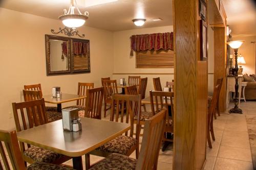 a dining room with wooden tables and chairs at All American Inn & Suites Branson in Branson