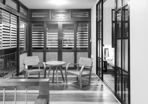 a dining room with a table and chairs and a bed at liaw base house in Bangkok