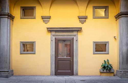 a yellow building with a door and windows at Palazzo Ridolfi - Residenza d'Epoca in Florence