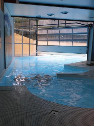 une grande piscine d'eau dans un bâtiment dans l'établissement Appartement Cauterets, à Cauterets