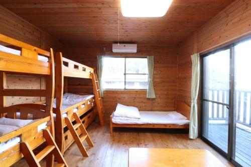a room with bunk beds in a wooden cabin at Maetakeso in Yakushima