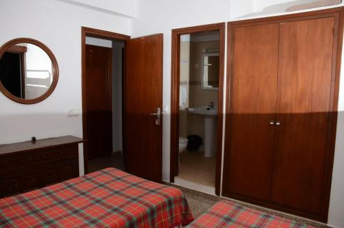 a bedroom with a bed and a mirror and a bathroom at Hostal Alocs in Es Figueral Beach