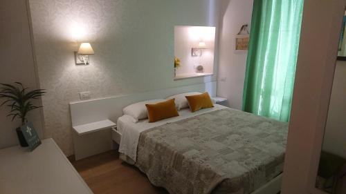 a bedroom with a bed with two orange pillows on it at Il Giglio Verde in Porto SantʼElpidio