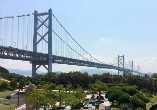 a bridge over a park with a cemetery under it at Hotel Trend Okayama Ekimae in Okayama