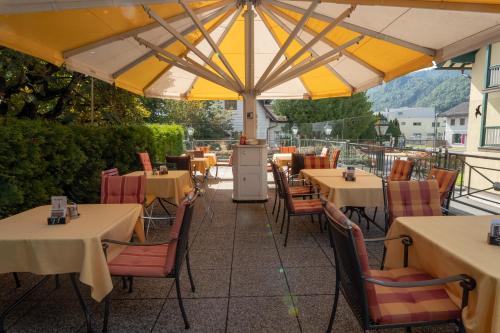 a restaurant with tables and chairs under a yellow umbrella at Brückenwirt in Hallein