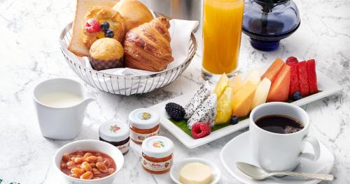 a table with a breakfast of bread and fruit and juice at Shangri-La Kuala Lumpur in Kuala Lumpur
