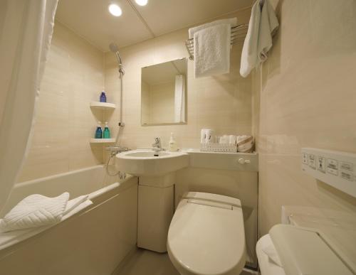 La petite salle de bains est pourvue de toilettes et d'un lavabo. dans l'établissement Red Roof Inn Kamata / Haneda Tokyo, à Tokyo