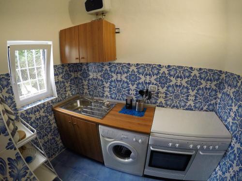 cocina con fregadero y lavadora en Villa La Mura, en Atrani