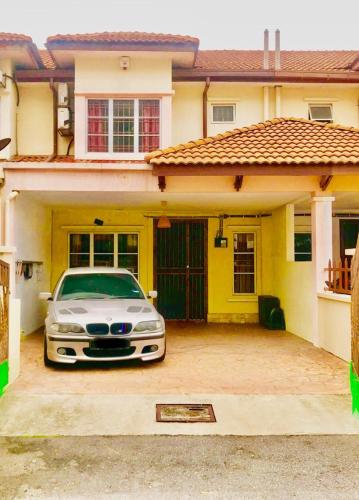 a white car parked in front of a house at HOMESTAY GOMBAK PERMAI in Batu Caves
