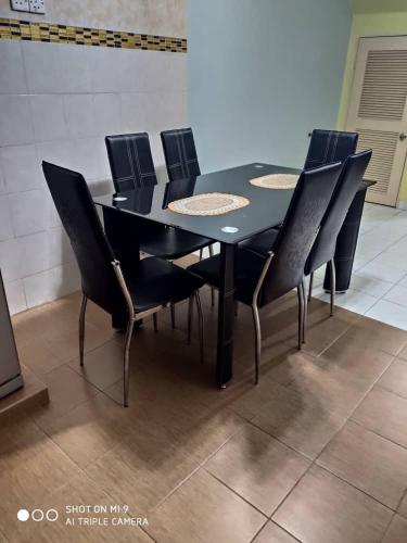 a black dining room table with black chairs at HOMESTAY GOMBAK PERMAI in Batu Caves