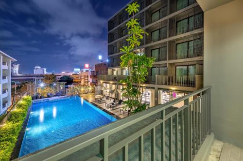 a balcony with a swimming pool and a building at PLAAI Prime Hotel Rayong SHA Extra Plus in Rayong