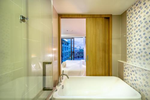 a bathroom with a bath tub and a shower at PLAAI Prime Hotel Rayong SHA Extra Plus in Rayong