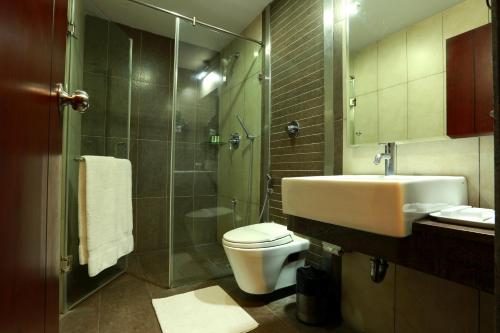 een badkamer met een toilet, een wastafel en een douche bij Hotel Abhimaani Vasathi, Rajajinagar in Bangalore