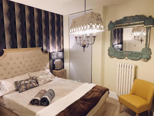 - une chambre avec un lit, une chaise et un miroir dans l'établissement Apartamento Plaza del Pilar, à Saragosse
