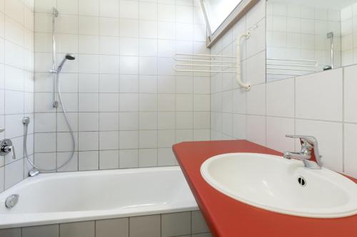 ein Badezimmer mit einem Waschbecken und einer Badewanne in der Unterkunft Berger Hof in Kressbronn am Bodensee