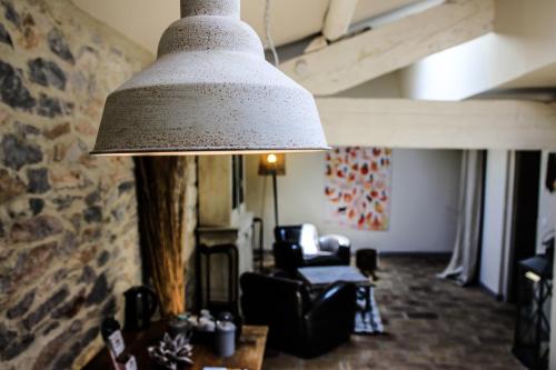 a large lamp hanging in a living room at Le Mas Des Brunes in Saint-Laurent-dʼAigouze