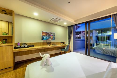 a hotel room with a bed and a desk at PLAAI Prime Hotel Rayong SHA Extra Plus in Rayong