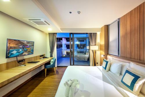 a hotel room with a bed and a tv at PLAAI Prime Hotel Rayong SHA Extra Plus in Rayong