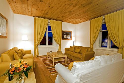 a living room with two couches and a table at Maloja Palace Suites CO2-Neutral in Maloja