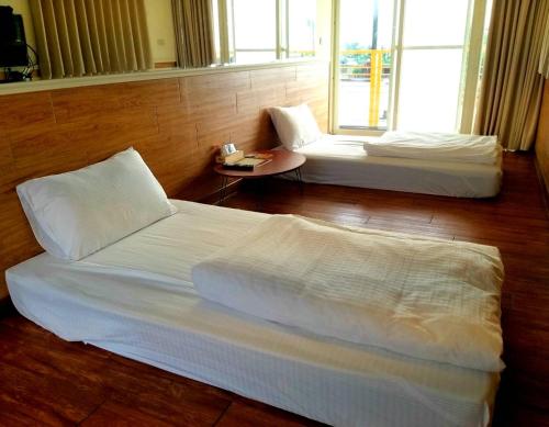 枋山鄉的住宿－東隆堂旅店，一间设有两张床和一张桌子的房间