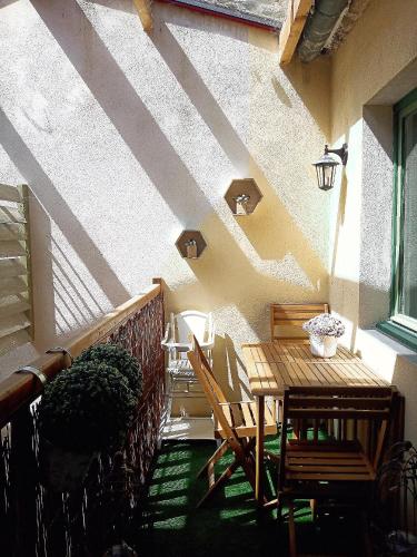 d'une terrasse avec une table et des chaises en bois sur un balcon. dans l'établissement S'House - Centre of Beaune, à Beaune