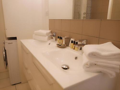La salle de bains est pourvue d'un lavabo et de serviettes. dans l'établissement S'House, à Beaune