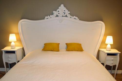 un lit blanc avec deux lampes sur deux tables dans l'établissement S'House - Centre of Beaune, à Beaune