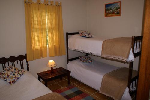 a room with two bunk beds and a lamp at Hotel Fazenda São Francisco in Cunha