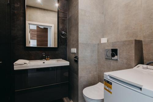 W łazience znajduje się umywalka, toaleta i lustro. w obiekcie ShortStayPoland Kolejowa (B10) w Warszawie