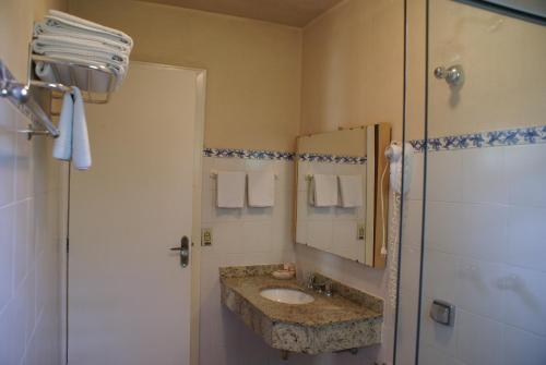 a bathroom with a sink and a mirror and a shower at Hotel Fazenda São Francisco in Cunha