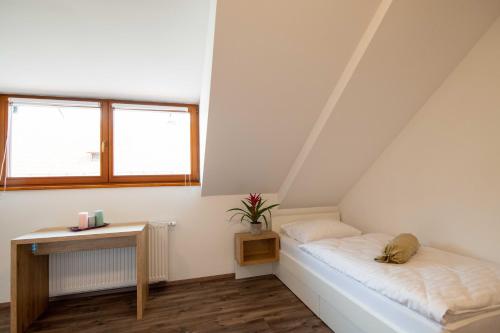 a attic room with a bed and a table at Guesthouse Stari Mayr in Kranj