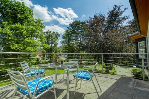 a patio with a table and chairs on a balcony at Villa Parkhaus in Wernigerode