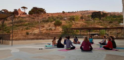 un groupe de personnes assises dans un cours de yoga dans l'établissement La Maison des Sources, à ‘Ayn Zḩaltā