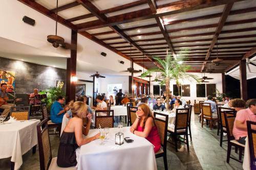 a group of people sitting at tables in a restaurant at Gaia Hotel & Reserve- Adults Only in Manuel Antonio