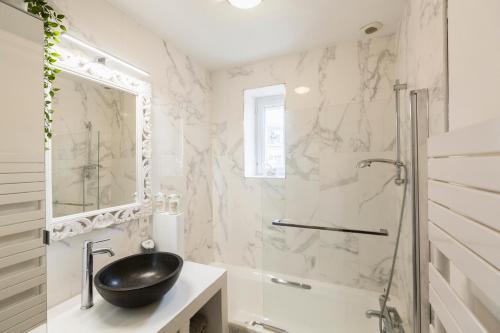 une salle de bain avec un lavabo, une baignoire et une douche dans l'établissement Sweet Home Paramé Saint Malo Petite vue mer, à Saint-Malo