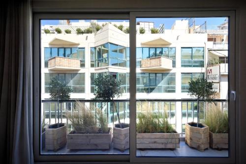 ein Fenster mit Topfpflanzen außerhalb eines Gebäudes in der Unterkunft Urban Melodies Apartment in Athen