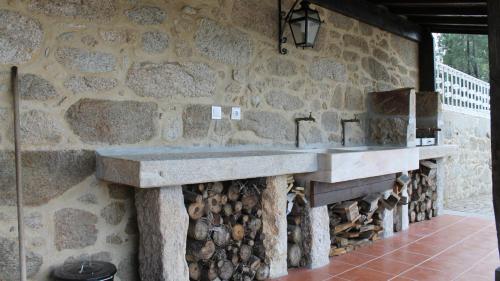a stone wall with a stone sink and a fireplace at Quinta Anna Horvath in Vale de Cambra
