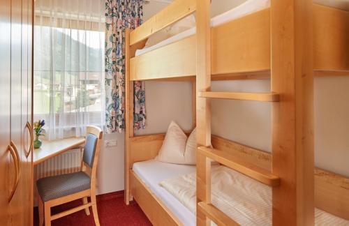 a room with a bunk bed and a desk at Jagdhof in Grossarl