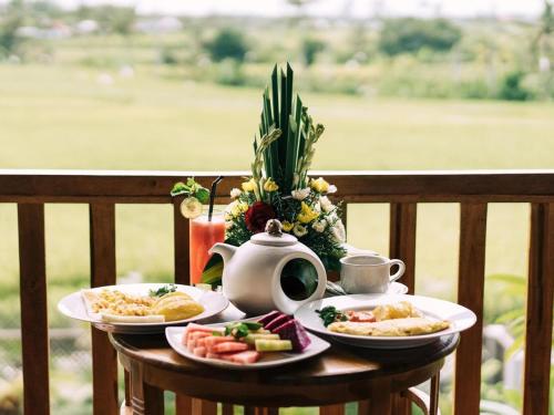 a table with plates of food and a tea pot at D'jineng Rice Terrace Canggu in Canggu