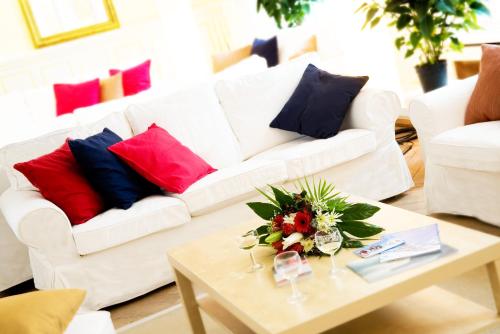 a living room with a white couch with colorful pillows at Maloja Palace Suites CO2-Neutral in Maloja