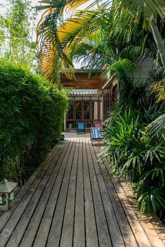 a wooden walkway leading to a house with plants at The Stage-Koh Chang in Ko Chang