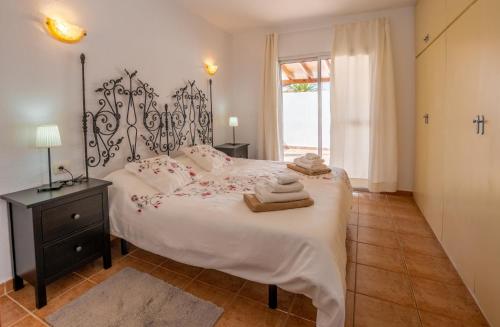 a bedroom with a large bed with towels on it at Villa Iris in Callao Salvaje