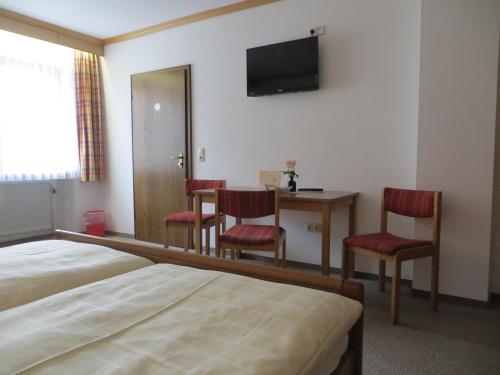 a hotel room with a bed and a table and chairs at Pension Leppert in Bischofsgrün