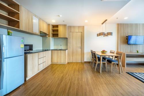 a kitchen with a table and a blue refrigerator at PLAAI Prime Hotel Rayong SHA Extra Plus in Rayong
