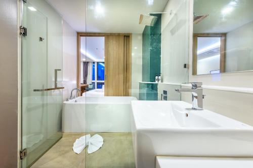a bathroom with a sink and a tub and a shower at PLAAI Prime Hotel Rayong SHA Extra Plus in Rayong