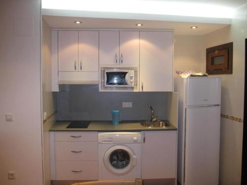 a kitchen with a washing machine and a microwave at La Casita Azul De Chillaron in Chillarón de Cuenca