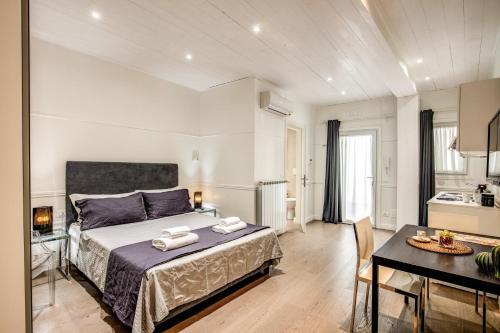 ローマにあるColosseo Suite Apartmentのベッドルーム1室(ベッド1台、テーブル付)、キッチン