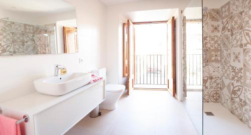 een badkamer met een wastafel, een toilet en een raam bij Can Calet in Marratxí 