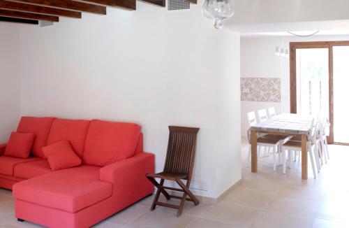 a living room with a red couch and a table at Can Calet in Marratxí 