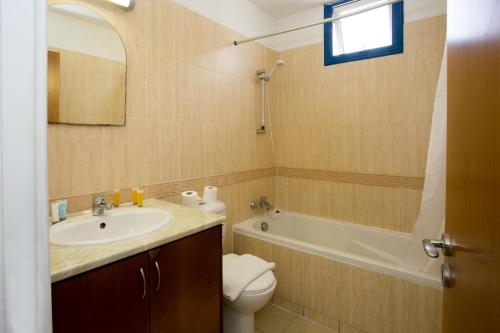 e bagno con lavandino, servizi igienici e vasca. di Sea CleoNapa Hotel a Ayia Napa